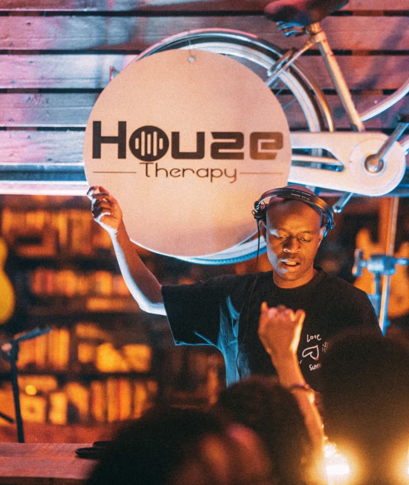 A DJ playing beneath the Houze Therapy sign
