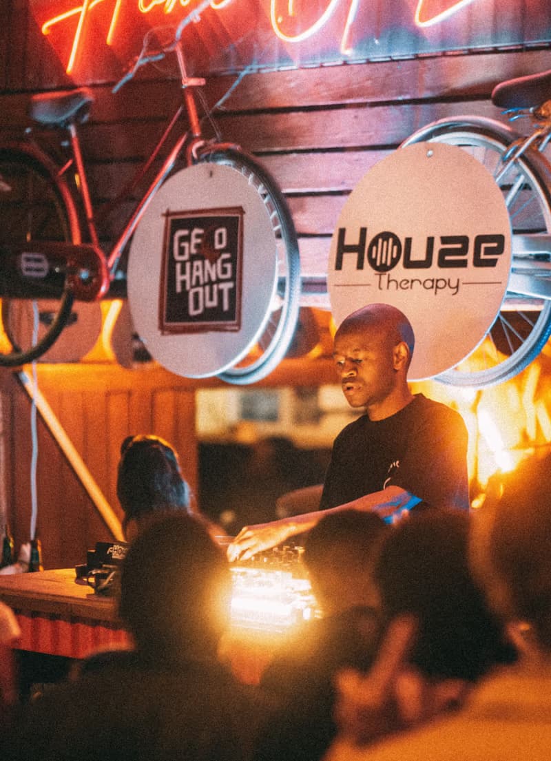 A chef at the grill under the Houze Therapy sign