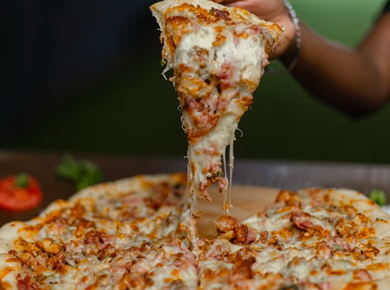 A slice of cheese pizza being lifted